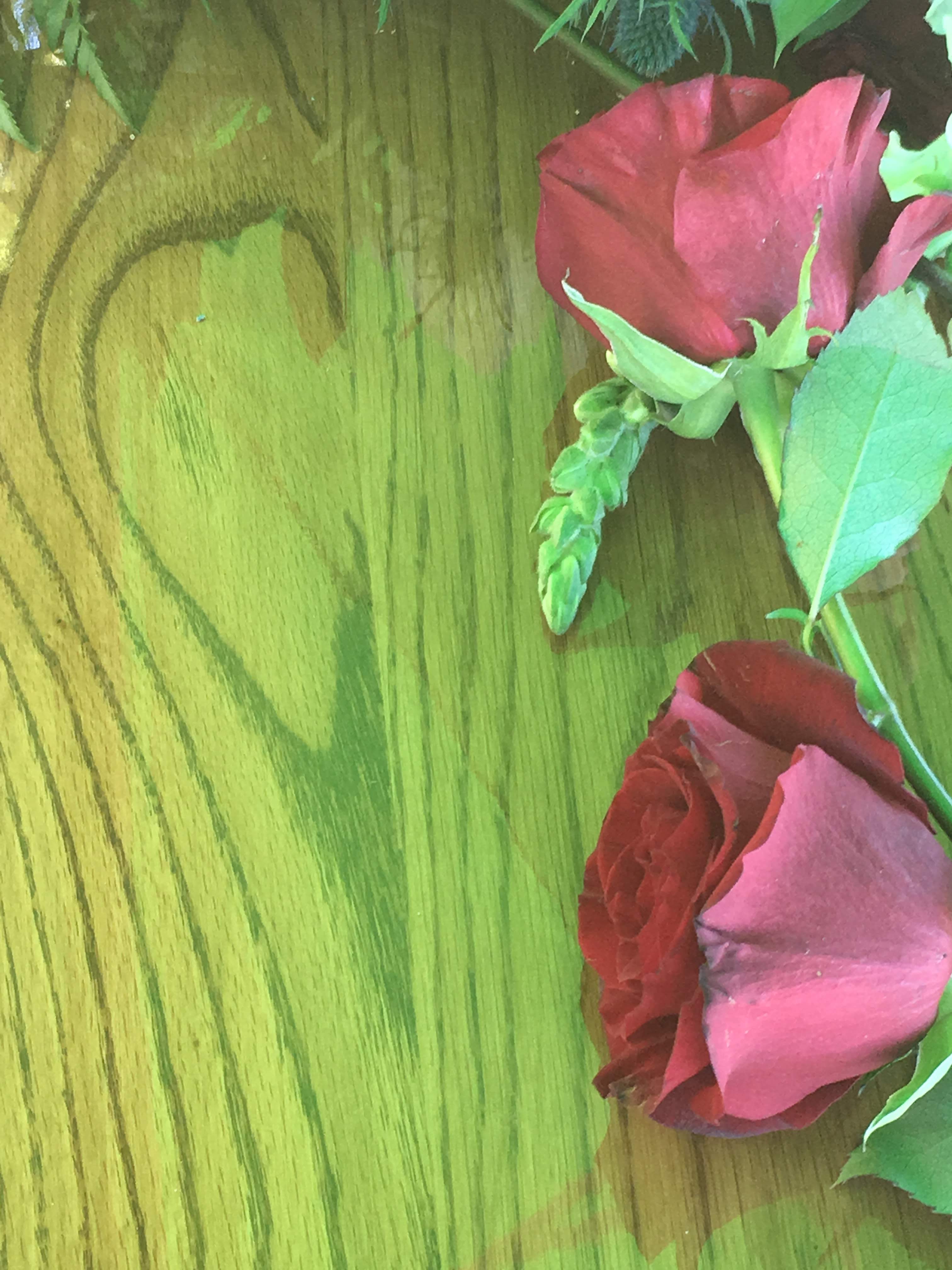 Heart-shaped grain in the wood of a casket with two red roses. 
