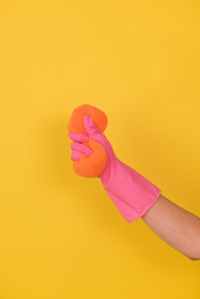 Hand with a cleaning glove, squeezing a sponge.